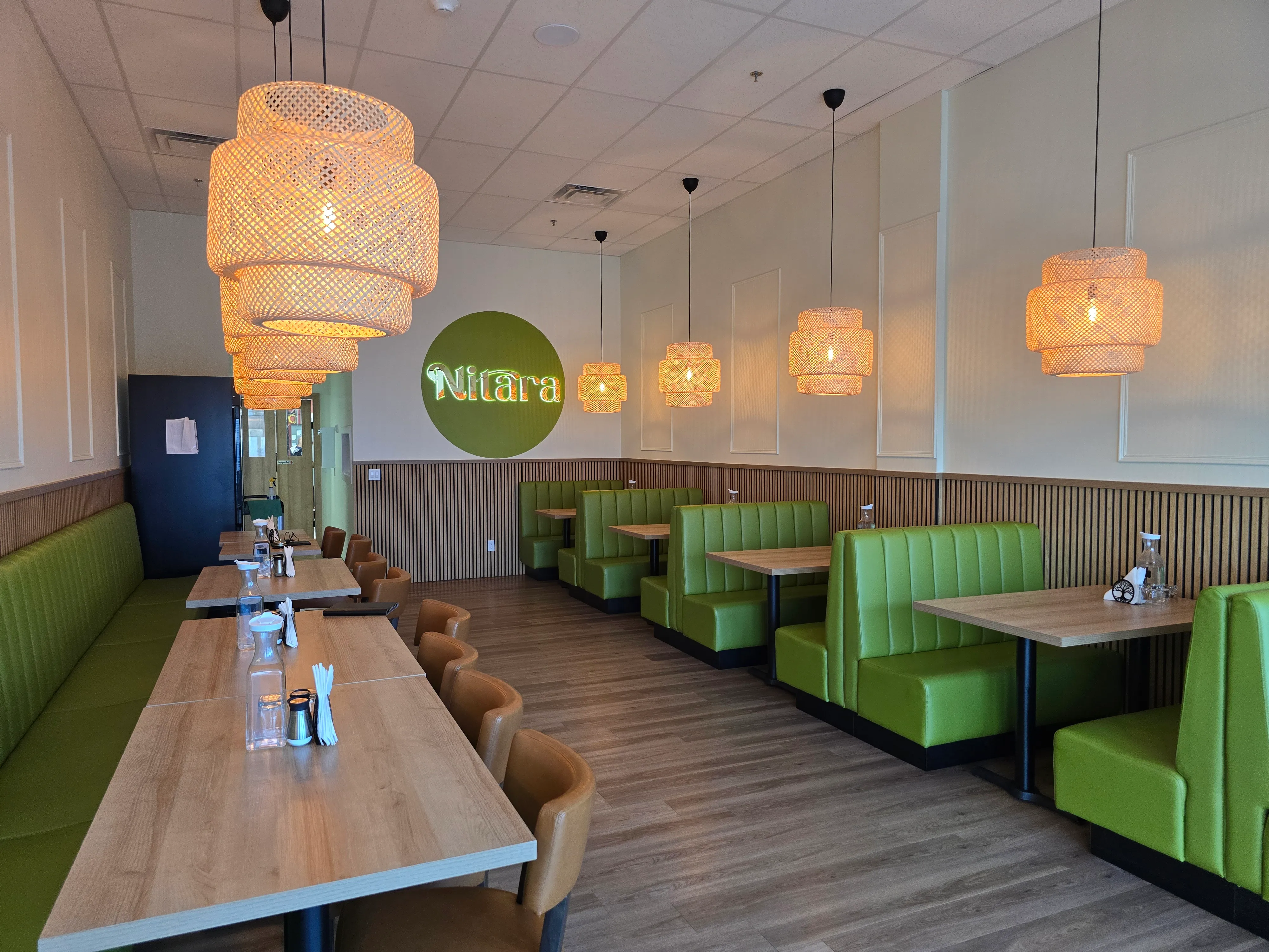 Dining room with booth seating inside Nitara - Flavours of South India restaurant in southwest Edmonton, AB